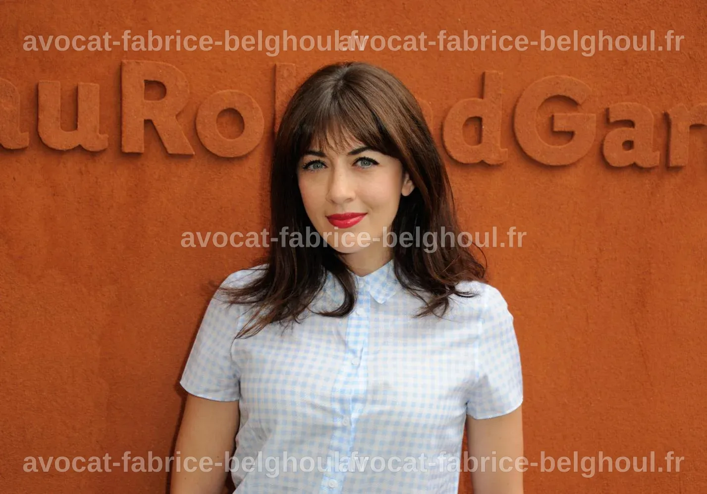 Nolwenn Leroy entourée de fleurs, célébrant sa grossesse avec joie.