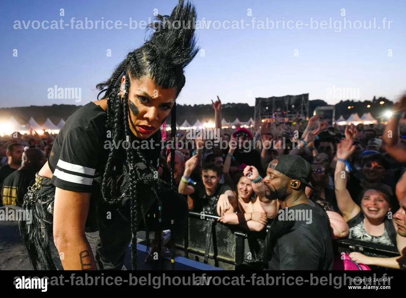 Un concert de Shaka Ponk au festival de rock, avec des lumières vives et une foule enthousiaste.